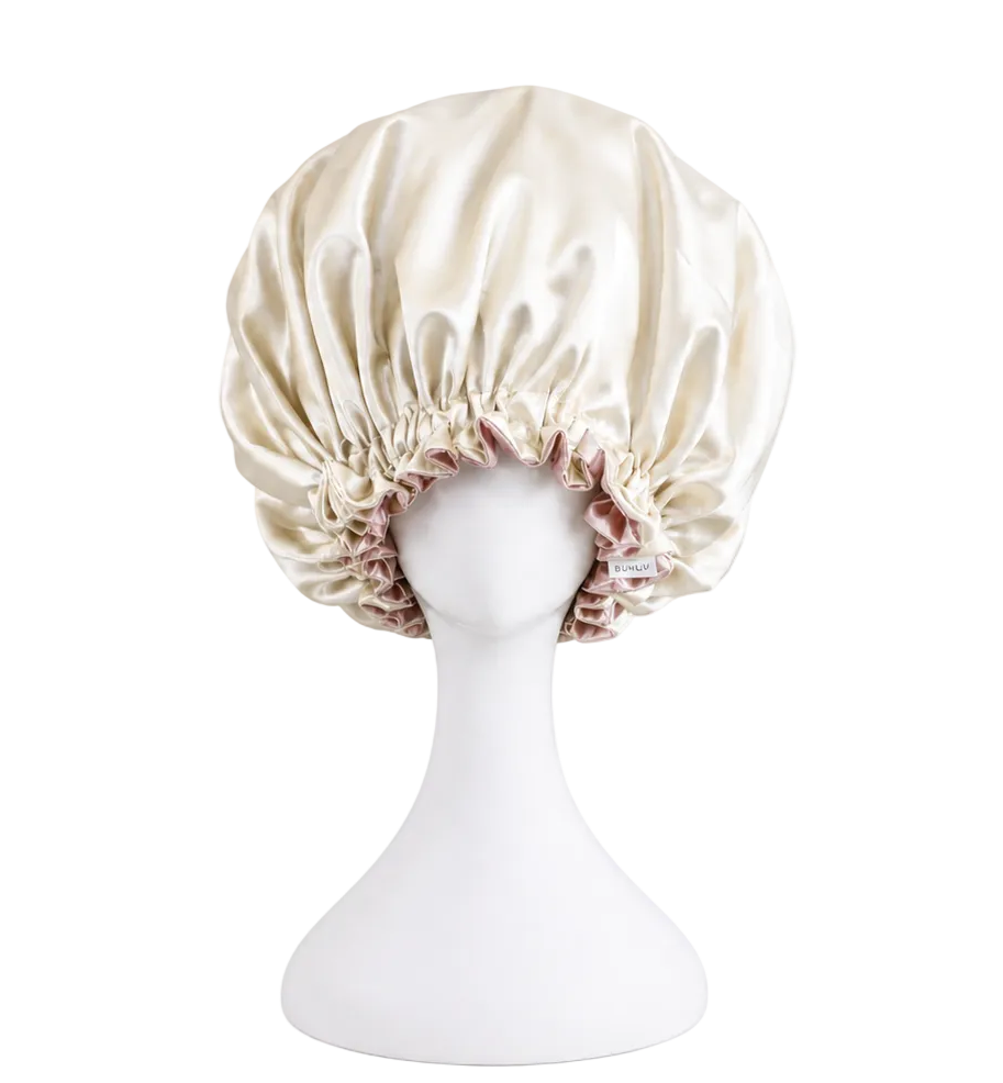 ivory satin bonnet on a mannequin head against a white background